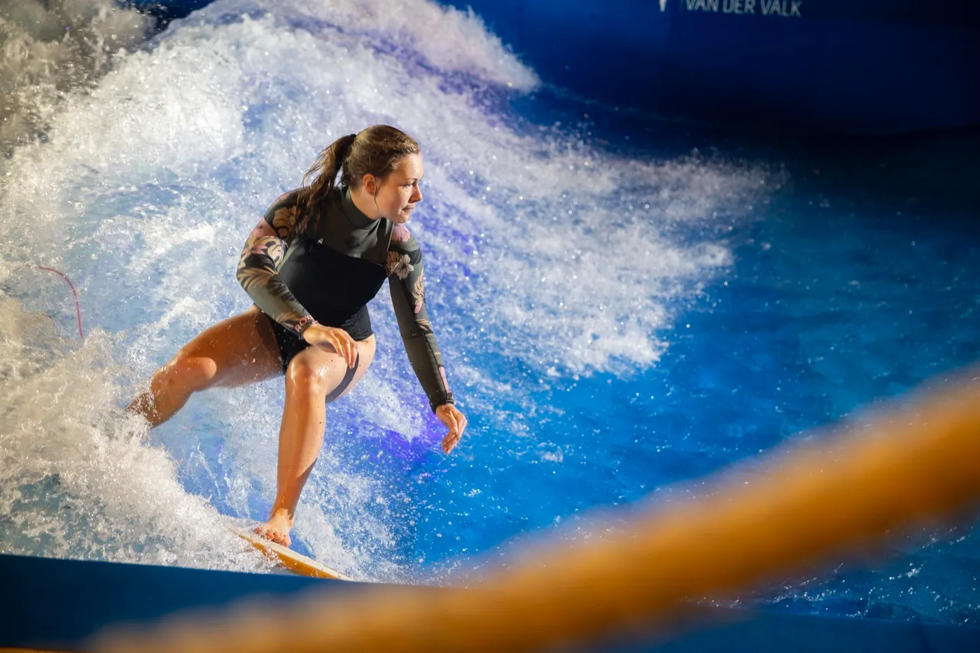 A woman riding the indoor wave at the hotel surf pool